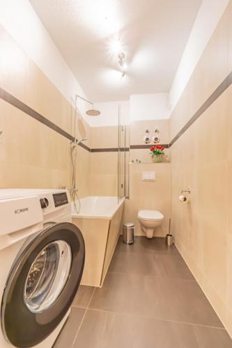 a washing machine in a bathroom with a toilet and a sink at Apartment am Altmarkt in Cottbus