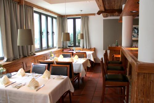 a dining room with tables and chairs and windows at Hotel Erzgiesserei Europe in Munich