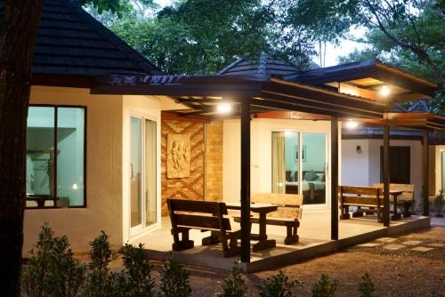 a house with a bench and a table on a patio at Avare House Krabi in Ao Nam Mao