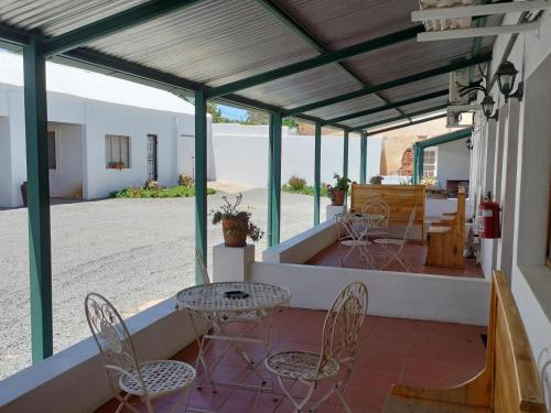 a patio with chairs and tables in a building at Rusgenot - Richmond, Karoo in Richmond