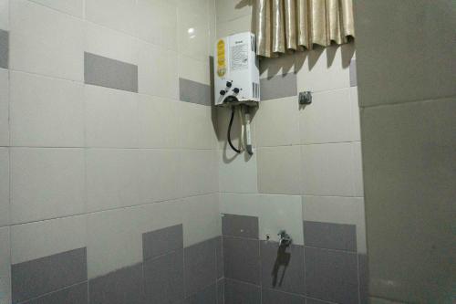 a man standing in a shower in a room at Jati Lawas Homestay Jogja by Anvia in Ngabean