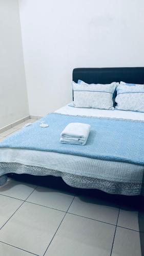 a bed with blue sheets and white pillows on it at Homestay Mdm Mai 2 in Masjid Tanah