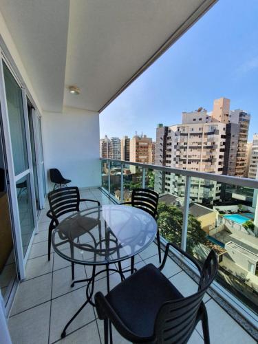 a balcony with chairs and a glass table on a balcony at Praia do canto apart 3 in Vitória