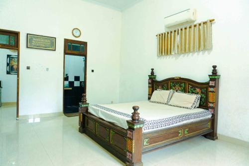 a bedroom with a wooden bed in a room at Jati Lawas Homestay Jogja by Anvia in Ngabean