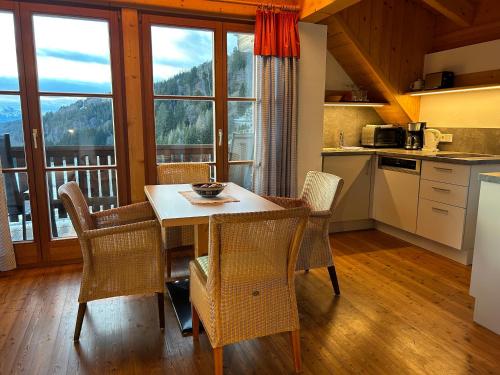 a kitchen with a table and chairs with a view at Mösslacher's Ferienwohnungen in Hermagor