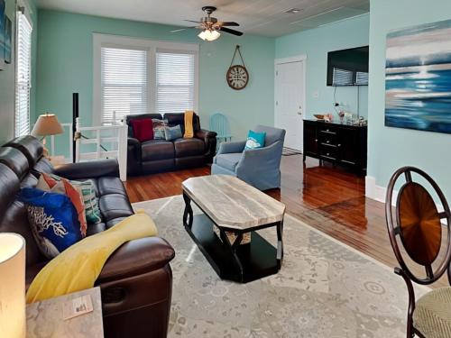 una sala de estar con un sofá y una mesa en Seawall Celebration - Up, en Galveston