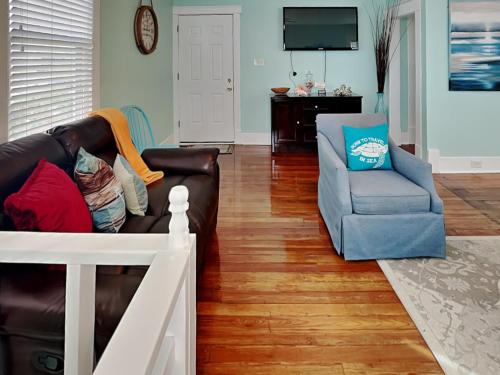 sala de estar con sofá de cuero y silla en Seawall Celebration - Up, en Galveston