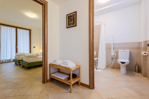 a bathroom with a mirror and a bed and a toilet at Cascina Borghetta in Sirmione