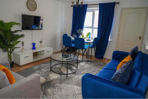 a living room with blue couches and a table at Milton Keynes Home - Sleeps 4 - Parking in Milton Keynes