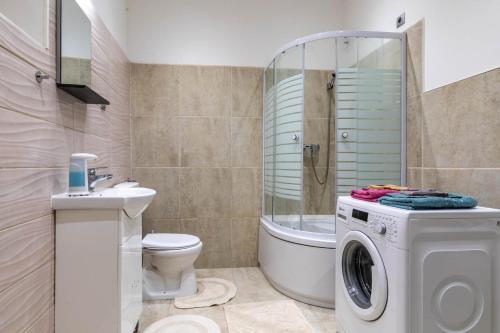 a bathroom with a washing machine and a toilet at Varkert Green 16 in Budapest