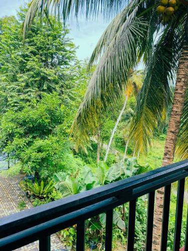 a balcony with a view of a palm tree at Stille Oase Inn in Matara