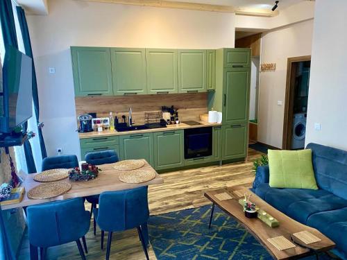 a kitchen with green cabinets and a table and a couch at Mavrovo_apt4 in Mavrovo
