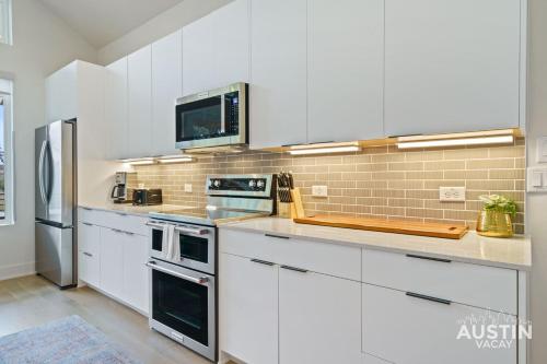 a white kitchen with white cabinets and appliances at Modern 3BR 3BA in Steiner Ranch w Balcony Dining Yard w Grill by Austin Vacay in Austin