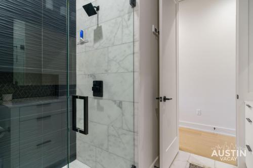 a bathroom with a shower with a glass door at Modern 3BR 3BA in Steiner Ranch w Balcony Dining Yard w Grill by Austin Vacay in Austin