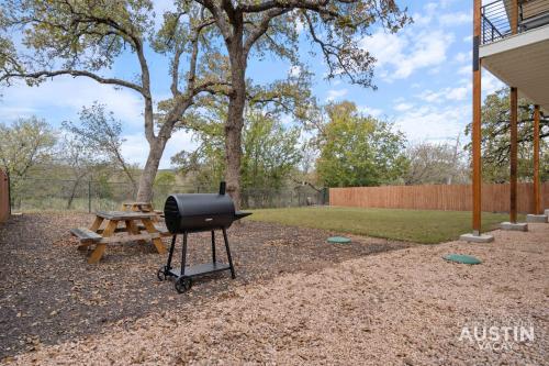 a barbecue grill and a picnic table in a yard at Modern 3BR 3BA in Steiner Ranch w Balcony Dining Yard w Grill by Austin Vacay in Austin