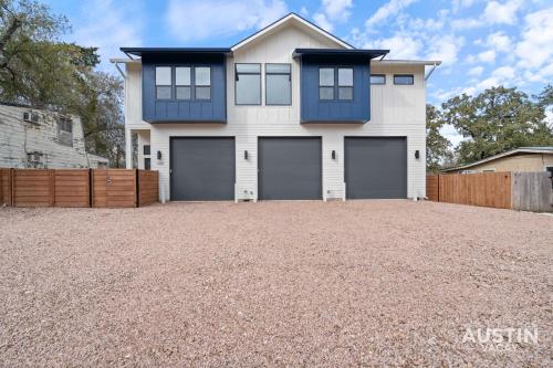 a house with two garage doors on a gravel driveway at Modern 3BR 3BA in Steiner Ranch w Balcony Dining Yard w Grill by Austin Vacay in Austin