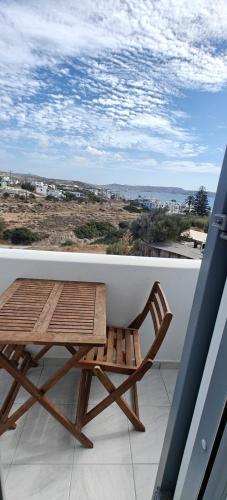a wooden chair sitting on top of a balcony at Joannes Vacation Rooms in Adamas