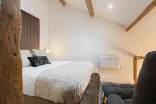 a bedroom with a bed and a chair at Bradford Luxury Central Apartment in Bradford