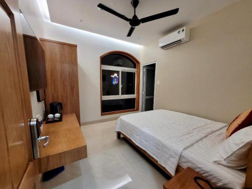 a bedroom with a bed and a ceiling fan at Khách Sạn Bảo Hoàng Vũng Tàu in Vung Tau