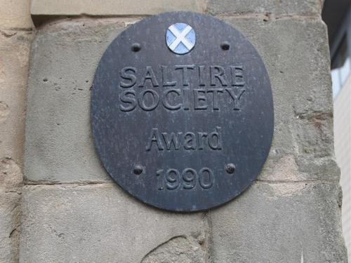 a plaque on the side of a stone wall at Glasgow city Charlotte service Aparments in Glasgow