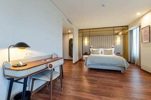 a hotel room with a bed and a desk at TURIM Lisboa Hotel in Lisbon