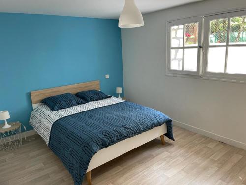 une chambre avec un lit aux murs bleus et une fenêtre dans l'établissement El Nido, à Saint-Georges-de-Didonne