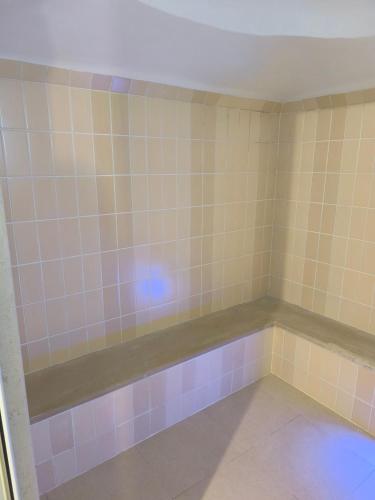 a bathroom with a tub with pink and blue tiles at Faraggi Hotel in Simvolí