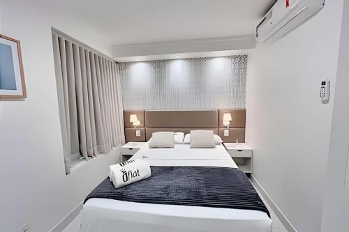 Un dormitorio blanco con dos camas y un cartel que dice "corre" en iFlat Metropoliran Barcelona MB205B Jardim Goiás, en Goiânia