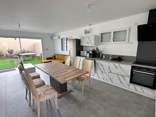 une cuisine et une salle à manger avec une table et des chaises en bois dans l'établissement Maison 40 avec 5 chambres lechaffardcom, à Satolas-et-Bonce