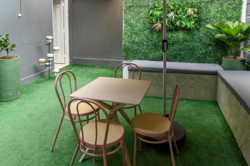 a table and chairs on a green floor at Hotel Hola Medellín in Medellín