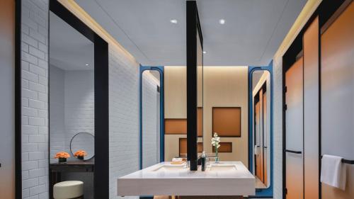 a bathroom with a white sink and a mirror at Hotel Indigo Yantai Golden Coast by IHG in Yantai