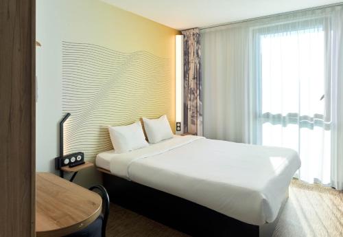 a hotel room with a large bed and a window at B&B HOTEL Paris Sud Chatenay Malabry in Châtenay-Malabry
