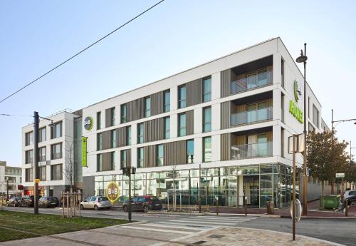 a large white building on a city street at B&B HOTEL Paris Sud Chatenay Malabry in Châtenay-Malabry