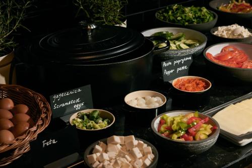 a buffet filled with bowls of different types of food at The Cloud One Gdansk in Gdańsk