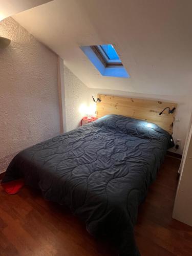 - une chambre avec un lit et une couette noire dans l'établissement Loc luz st sauveur 1, à Luz-Saint-Sauveur