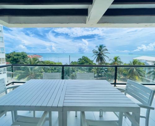 a table on a balcony with a view of the ocean at Bay Point- Ocean View Apartments by NIDHO PROPERTIES in San Andrés