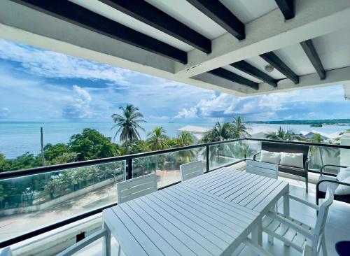 a balcony with a table and chairs and the ocean at Bay Point- Ocean View Apartments by NIDHO PROPERTIES in San Andrés