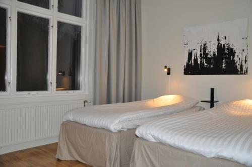 two beds in a room with a window at Spånhults Herrgård Hotel in Norrahammar