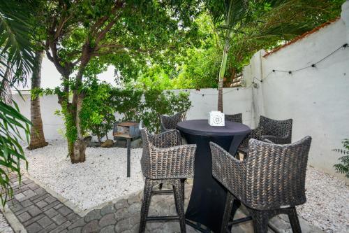 a table and chairs in a courtyard with trees at Aloe B&B in Oranjestad