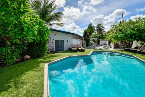 a swimming pool in the yard of a house at Aloe B&B in Oranjestad