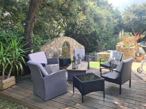 a deck with chairs and a table and a table at L'Abrialys in Lorgues