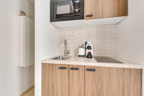 une cuisine avec un évier et un micro-ondes dans l'établissement Magnifique Studio ile saint louis - Paris 4 - 2P - FLAT-GUEST, à Paris