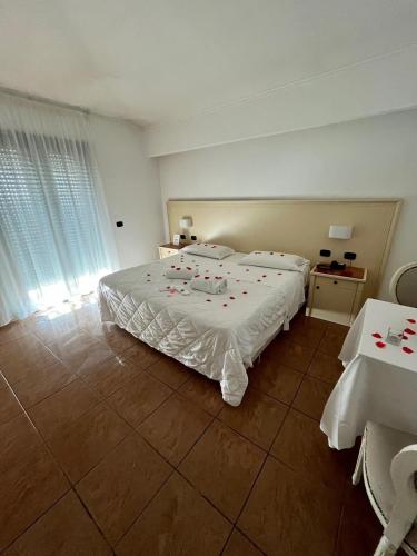 a bedroom with a large bed with red roses on it at Hotel Giulia Ocean Club in Qualiano