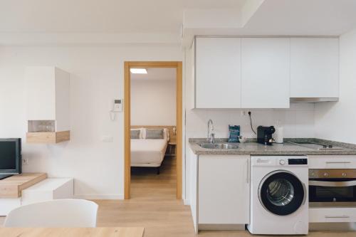 a kitchen with a washer and dryer in a room at Pio XII Apartments Valencia in Valencia