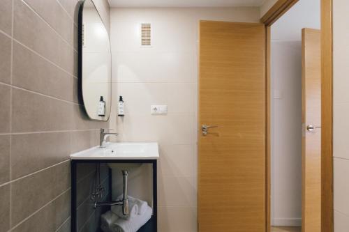 a bathroom with a sink and a mirror at Pio XII Apartments Valencia in Valencia