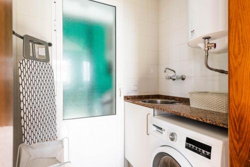 a bathroom with a washing machine and a sink at 3 Bedroom Villa, 300m to Arenal d'en Castell Beach in Punta Grossa