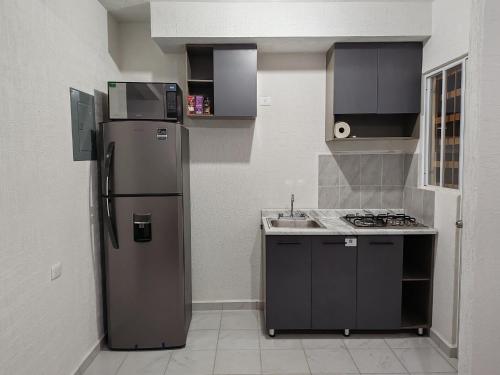a small kitchen with a refrigerator and a sink at Privada Monte Aneto 13 in Cancún