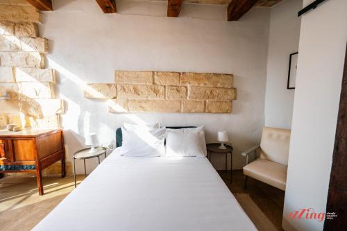 a bedroom with a white bed and a desk at Charming Village Escape with Jacuzzi & Games Room in Rabat