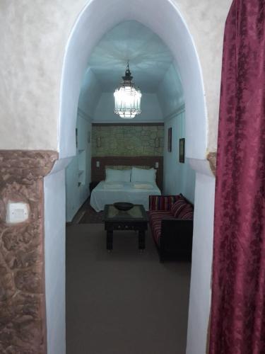 a bedroom with a bed and a chandelier at Dar Chamss in Taroudant