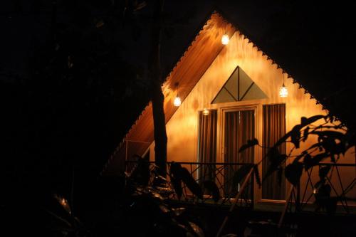 a house with lights on the side of it at night at Wood Castle Munnar in Munnar